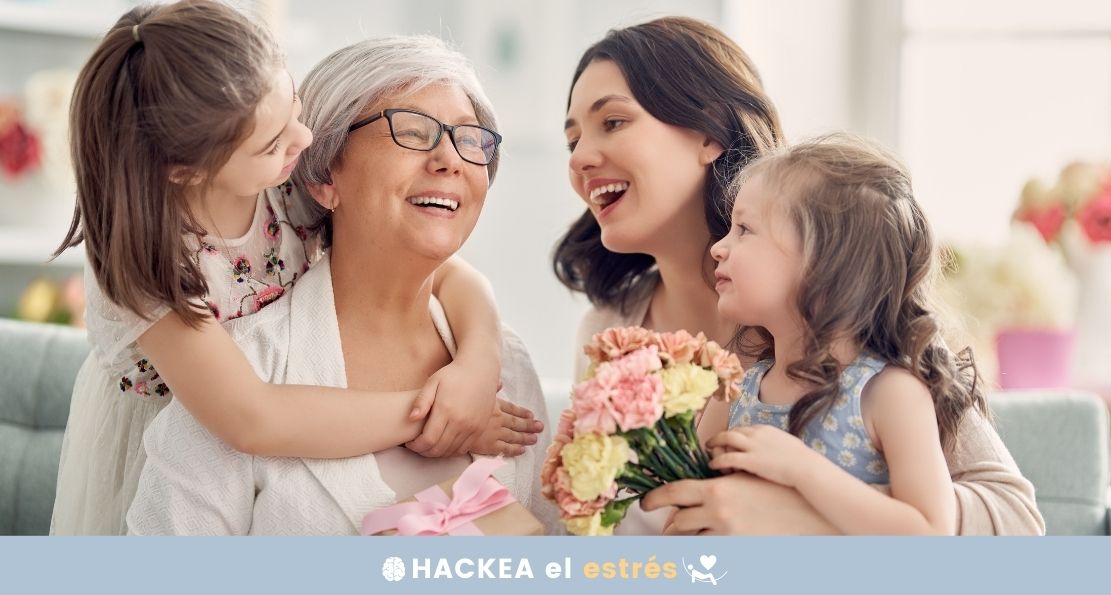 imagen de abuela, madre y dos niñas intercambiando abrazos y flores